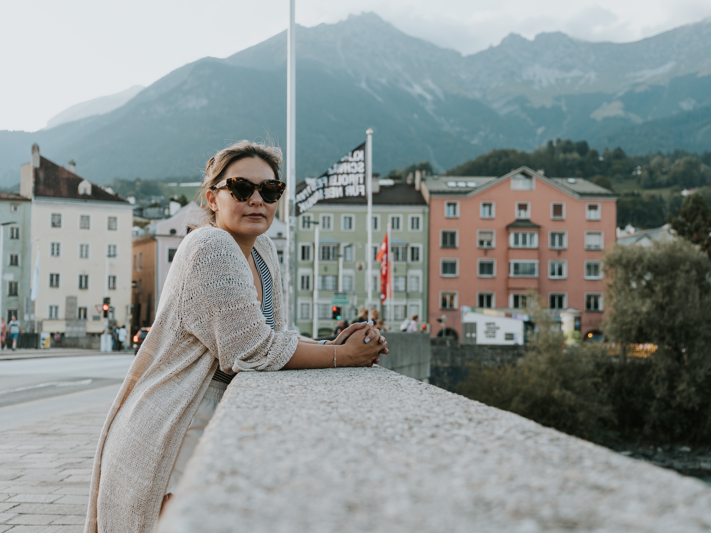 Standing in front of the colorful architecture and alpine mountains of Innsbruck